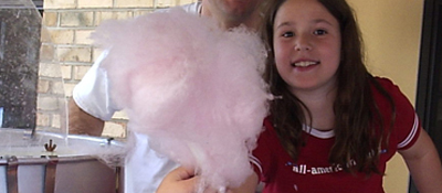 Young girl holding cotton candy at a school carnival