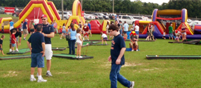 Inflatable fun games outside on a field at a school fun fair carnival